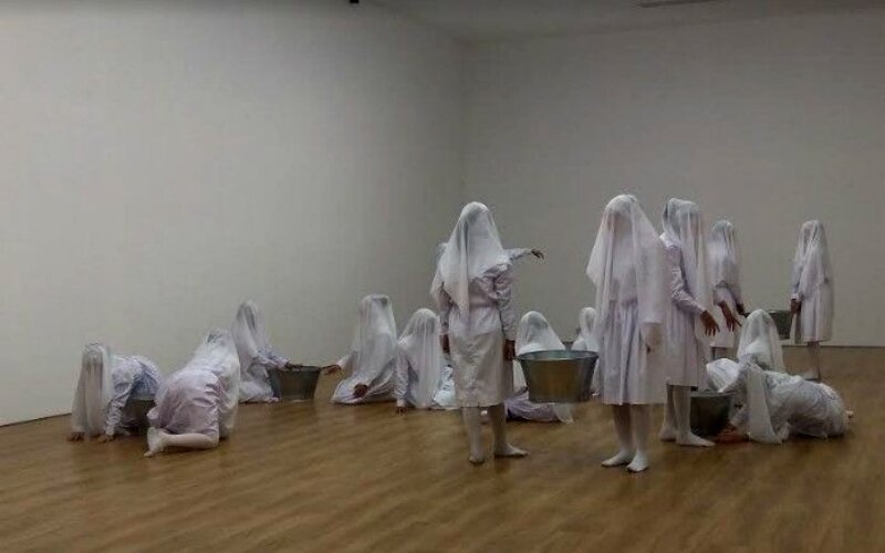 Sweet Dreams Sweet (2003) karya Melati Suryodarmo yang menampilkan 30 perempuan dengan seragam berwarna putih dan wajah tertutup berinteraksi dengan satu sama lain lewat gerakan. -Dok. suara.com
