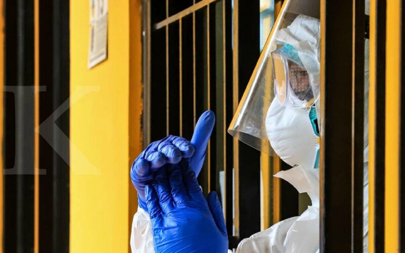 Seorang petugas Ahli Teknologi Laboratorium Medik menyampaikan isyarat kepada rekannya saat proses pemeriksaan metode swab test di Laboratorium Kesehatan Daerah, Depok, Jawa Barat, Senin (6/4/2020). -Dok. KONTAN/Fransiskus Simbolon.