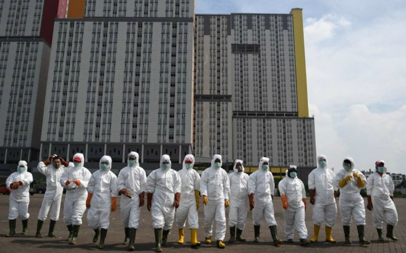 Petugas Palang Merah Indonesia (PMI) berjalan untuk melakukan penyemprotan cairan disinfektan pada Wisma Atlet di Kemayoran, Jakarta, Sabtu (2132020). -Dok. ANTARA FOTO/M. Risyal Hidayat.