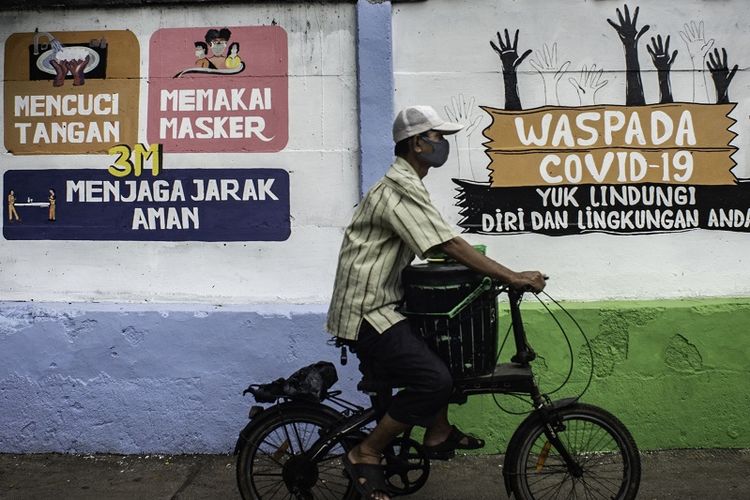 Pada Rabu (16/9/2020) warga berjalan di depan sebuah mural berisi pesan peringatan penyebaran virus corona di Pettah, Jakarta.  Mural ini dibuat untuk mengingatkan masyarakat agar menggunakan protokol kebersihan saat beraktivitas, mengingat kasus COVID-19 yang banyak terjadi di seluruh negeri.  Foto / Aprilio Akbar / aww.