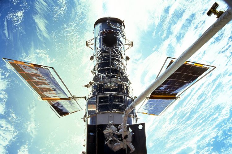 Foto NASA / JSC ini menunjukkan astronot Steven L. Smith dan John M. Grinsfield selama Operasi ExtraVahular (EVA) pada bulan Desember 1999 di pemeliharaan Teleskop Hubble.