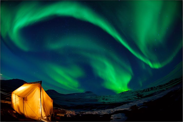 Deskripsi mendirikan tenda di bawah langit luas Aurora Borealis.