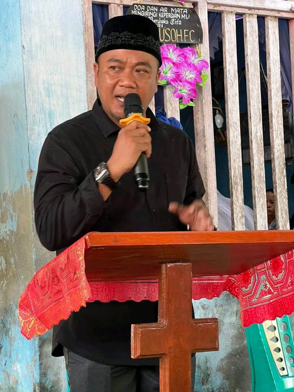 H.  Aryanto Banio menyampaikan pidato di upacara pemakaman Kristen.